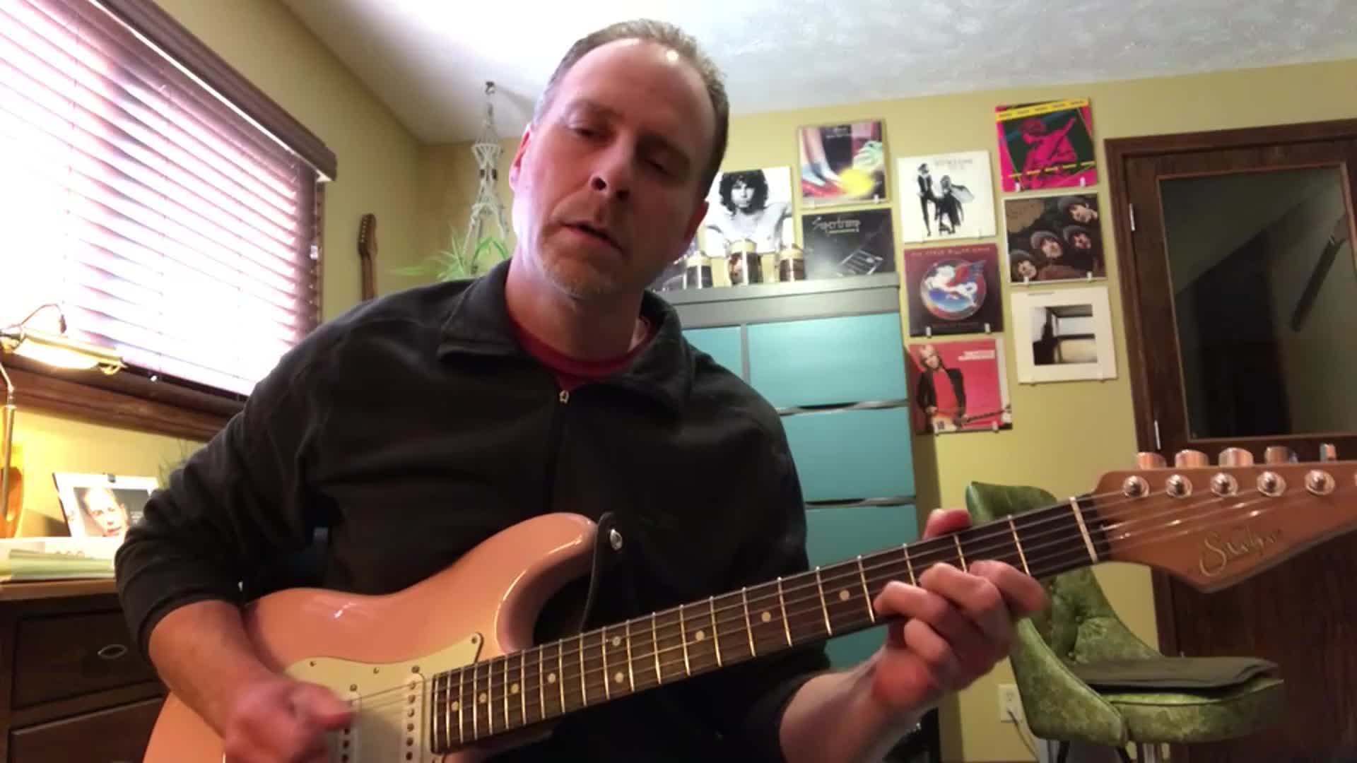 Erik playing guitar on camera from his practice room